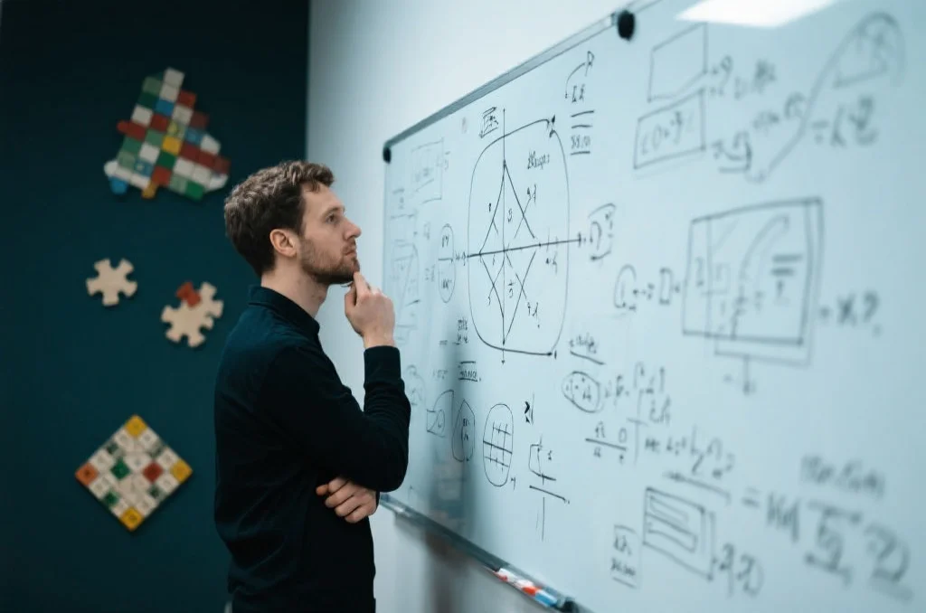 一个人正在思考白板上的复杂问题，象征着批判性思维和问题解决能力